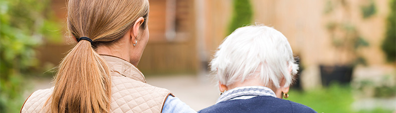 Two people walking away, one taller and younger and one shorter and older with white hair