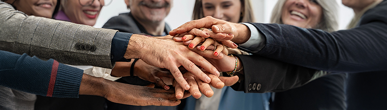 group of diverse business people with hands together in team building exercise